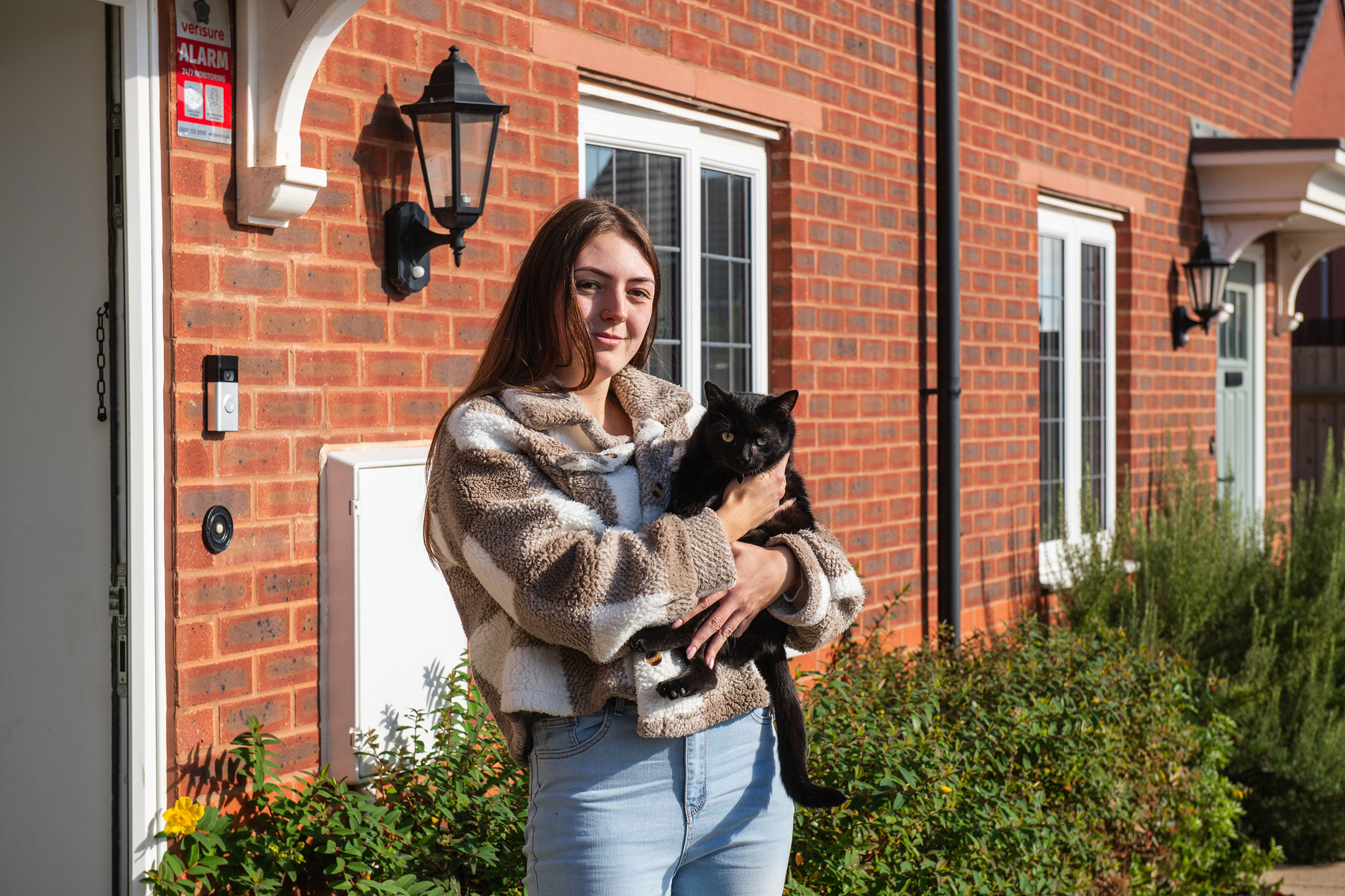 A Sparrow customer holding a cat in doorway